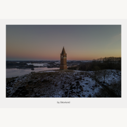 Vinterlandskab ved Himmelbjerget med t�rn, sne og d�mpet aftenslys over s� og bakker.